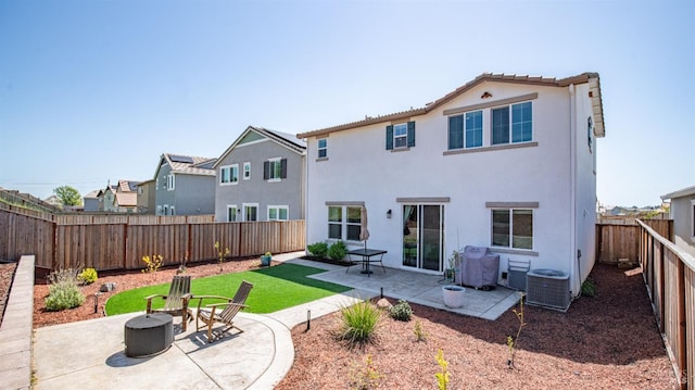 back of property featuring a tiled roof, a fire pit, a fenced backyard, a patio, and stucco siding
