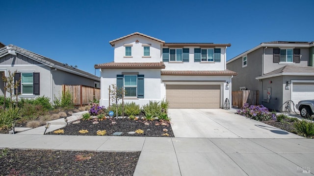 view of front of house featuring a tile roof, fence, and a garage