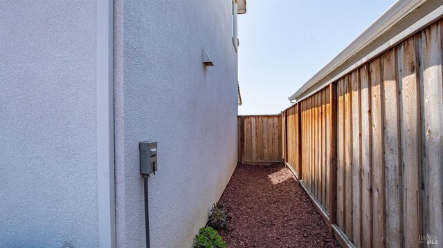 view of home's exterior with stucco siding and fence