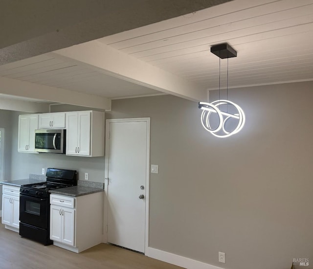 kitchen featuring light wood-style floors, stainless steel microwave, white cabinets, wooden ceiling, and black range with gas cooktop