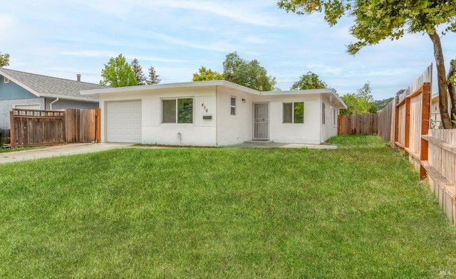 ranch-style home featuring concrete driveway, a garage, a fenced backyard, and a front lawn