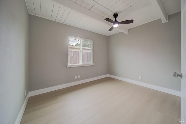 unfurnished room with baseboards, ceiling fan, wood finished floors, and beam ceiling