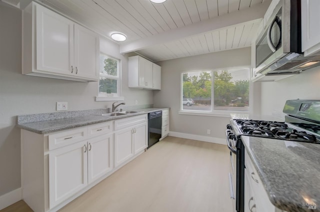 kitchen featuring baseboards, white cabinets, a sink, light wood-style flooring, and appliances with stainless steel finishes
