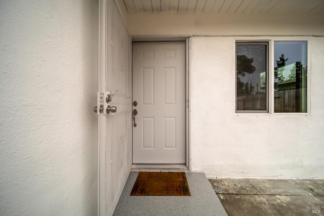 doorway to property featuring stucco siding