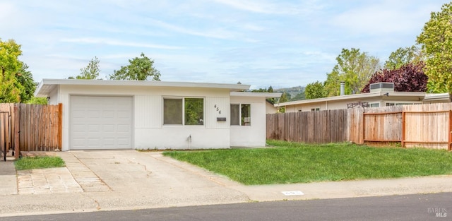 view of front of property featuring fence, driveway, and a front lawn