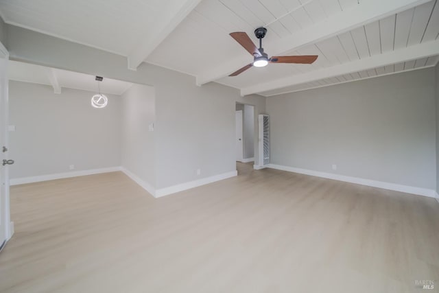 spare room featuring light wood-style floors, baseboards, and beamed ceiling