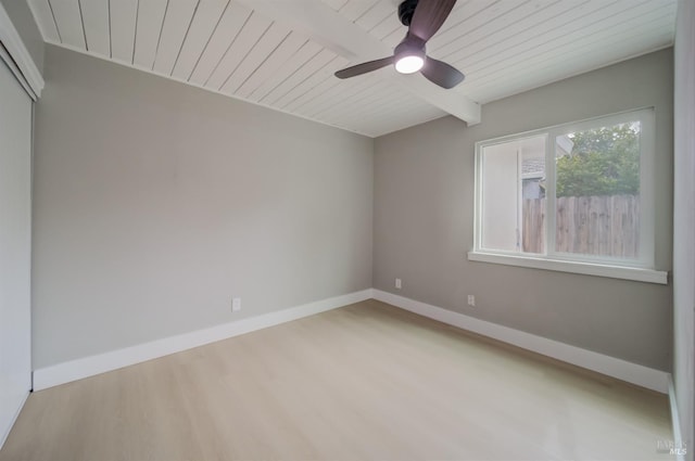 empty room with wood finished floors, beamed ceiling, baseboards, ceiling fan, and wooden ceiling