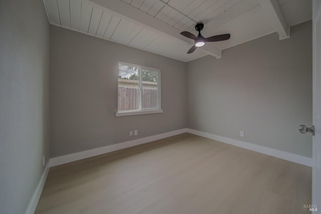 unfurnished room featuring baseboards, a ceiling fan, wood finished floors, and beamed ceiling