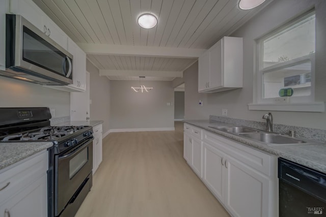 kitchen with a sink, light countertops, white cabinets, black appliances, and light wood finished floors