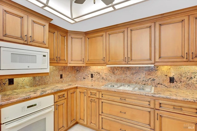 581 Werner Way, Vacaville, CA 95688 - kitchen featuring white appliances, backsplash, light stone countertops, brown cabinets, and ceiling fan