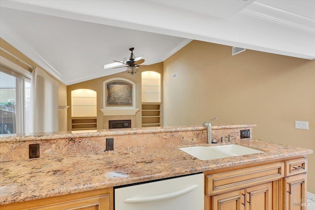 581 Werner Way, Vacaville, CA 95688 - kitchen featuring a sink, white dishwasher, ceiling fan, light stone counters, and a glass covered fireplace