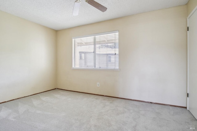 empty room with a ceiling fan, baseboards, carpet, and a textured ceiling