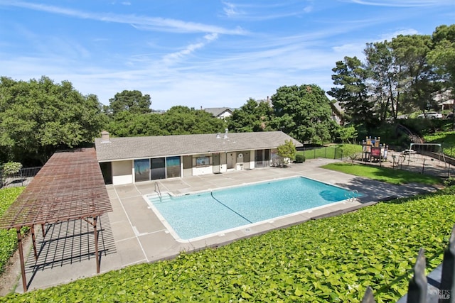 community pool with a patio and fence