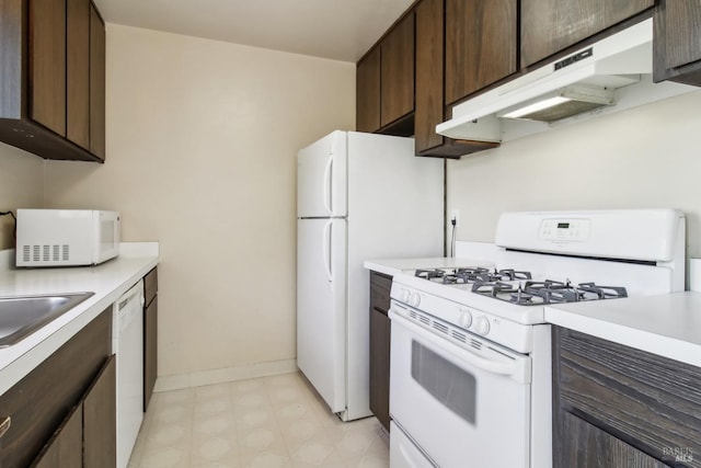 kitchen featuring under cabinet range hood, light countertops, white appliances, and dark brown cabinetry