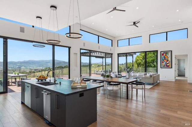 kitchen with open floor plan, ceiling fan, a mountain view, dark cabinets, and a sink
