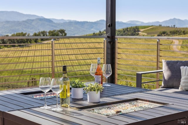 wooden deck featuring a mountain view, a rural view, and an outdoor fire pit