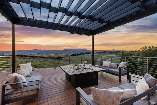 wooden terrace featuring an outdoor living space with a fire pit and a mountain view