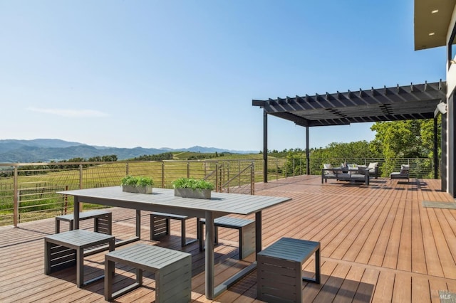 wooden terrace with a pergola, a rural view, outdoor dining area, and a mountain view