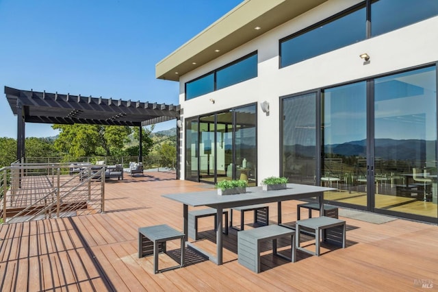 deck featuring outdoor dining area and a pergola