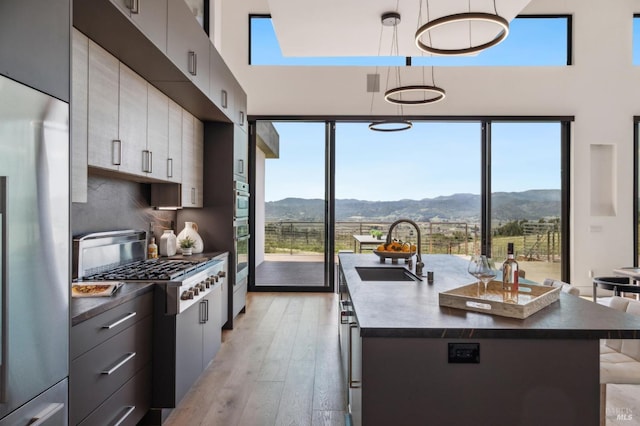 kitchen with a sink, appliances with stainless steel finishes, a mountain view, and dark countertops
