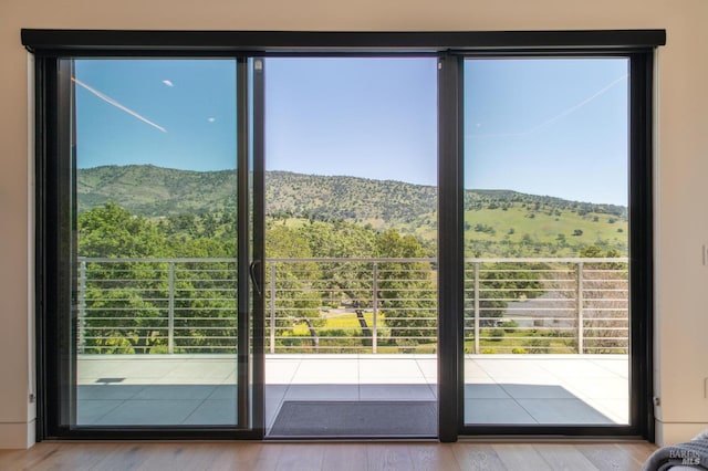 doorway to outside with a mountain view and wood finished floors
