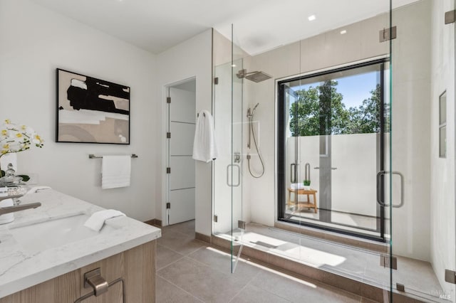 bathroom with double vanity, tile patterned floors, a shower stall, and a sink