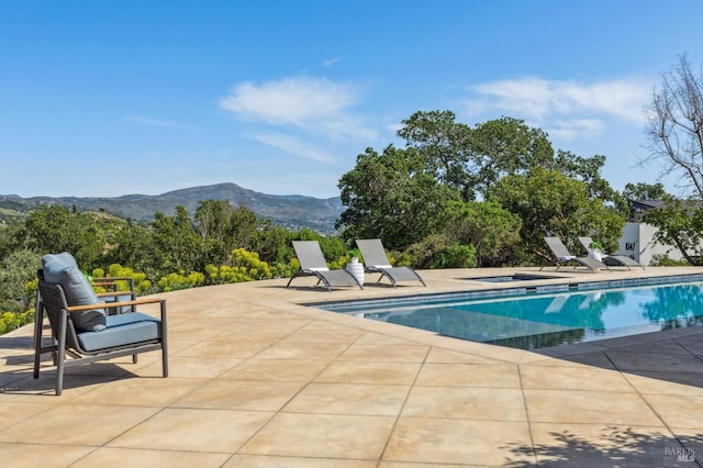 pool with a patio, a mountain view, and a jacuzzi