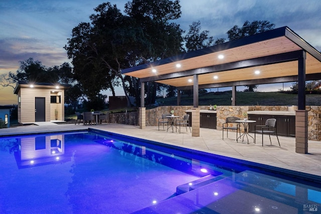 view of swimming pool with fence, a gazebo, a pool with connected hot tub, and a patio area