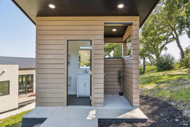 doorway to property featuring a sink and metal roof