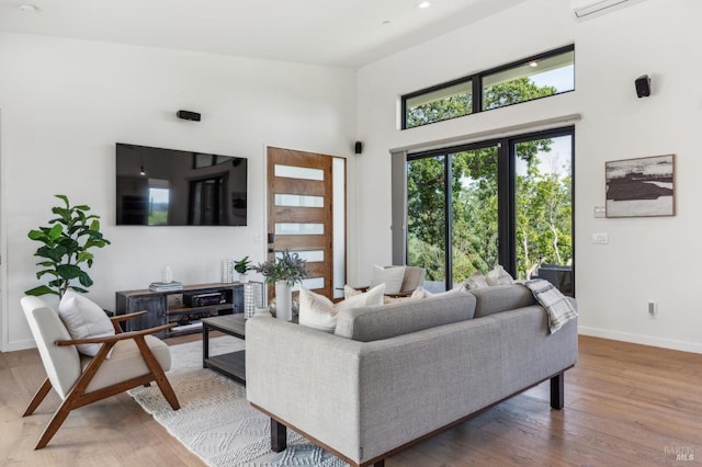 living room with baseboards, wood finished floors, and a high ceiling