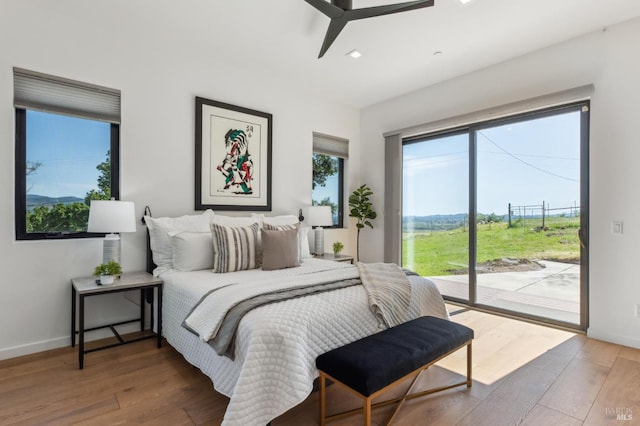 bedroom featuring baseboards, recessed lighting, wood finished floors, and access to exterior