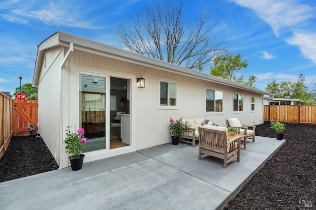 back of property featuring a fenced backyard, a patio, and an outdoor living space