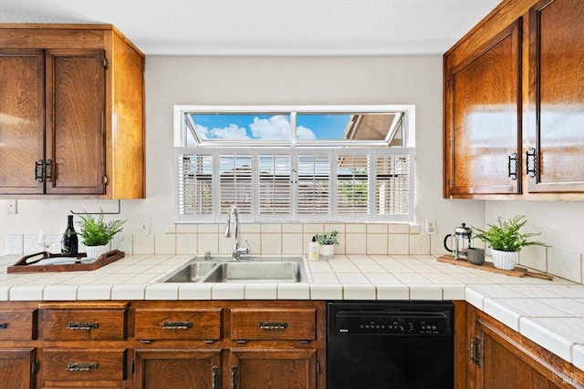 kitchen with dishwasher, brown cabinetry, a sink, and light countertops