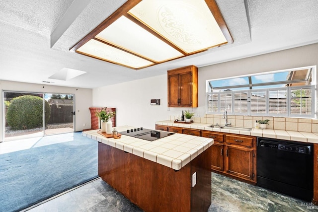 kitchen with tile countertops, a sink, a kitchen island, black appliances, and a textured ceiling
