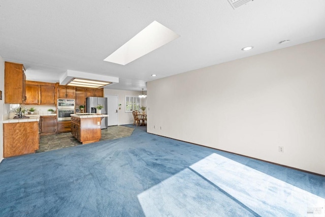 living room featuring a skylight, dark carpet, and recessed lighting