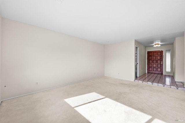 unfurnished living room with baseboards and carpet