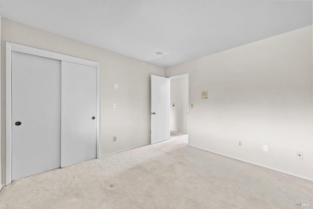 unfurnished bedroom with a closet, carpet flooring, and baseboards