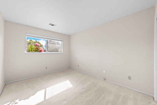 spare room featuring visible vents, carpet flooring, and baseboards