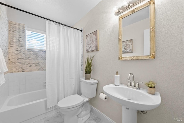 full bathroom with a sink, marble finish floor, shower / bath combination with curtain, a textured wall, and toilet
