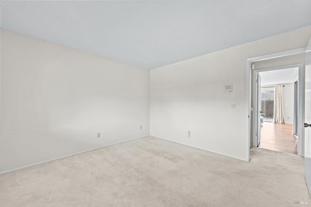 carpeted spare room featuring baseboards