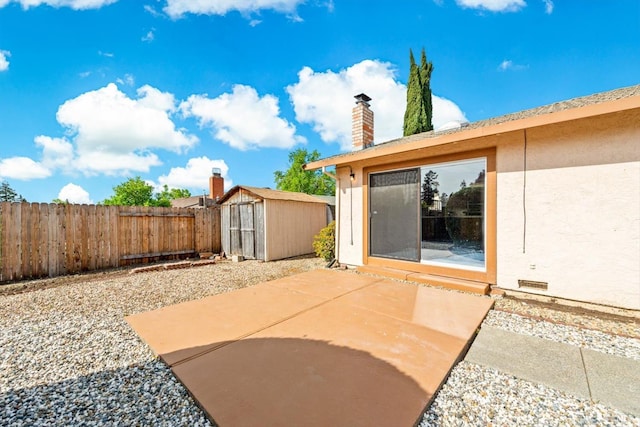 view of patio / terrace featuring a storage unit, an outbuilding, and a fenced backyard