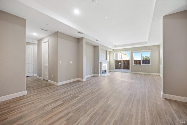 unfurnished living room featuring recessed lighting, visible vents, light wood finished floors, and baseboards