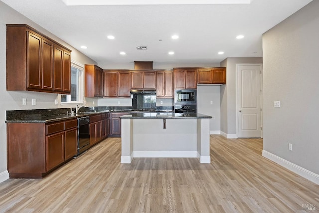 kitchen featuring under cabinet range hood, visible vents, light wood-type flooring, baseboards, and black appliances