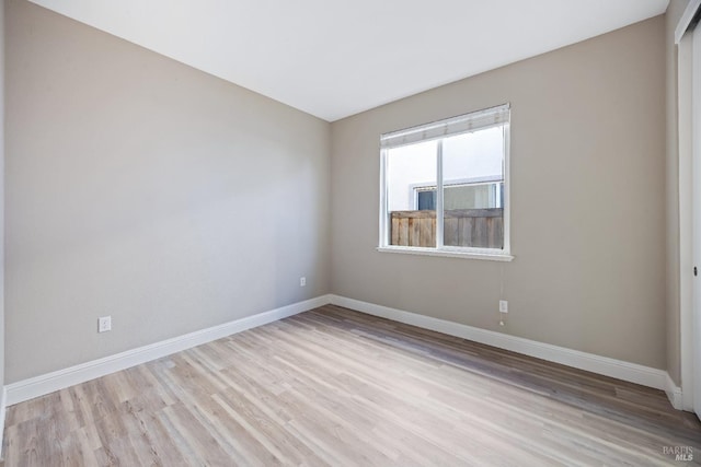 empty room with baseboards and wood finished floors