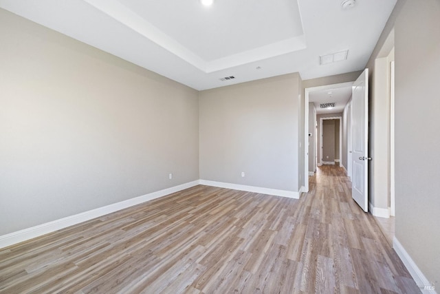 unfurnished room with baseboards, light wood-style floors, and visible vents