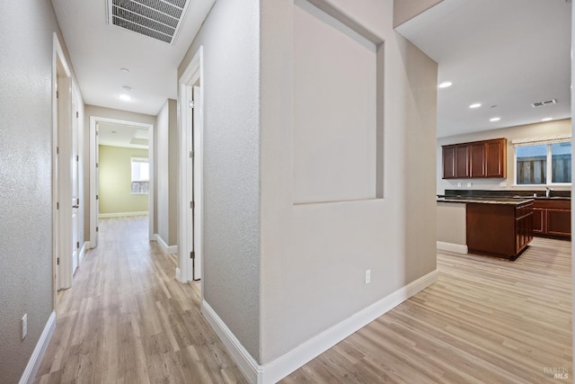 corridor with baseboards, light wood-style flooring, visible vents, and recessed lighting