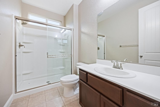 bathroom featuring tile patterned flooring, vanity, toilet, and a stall shower