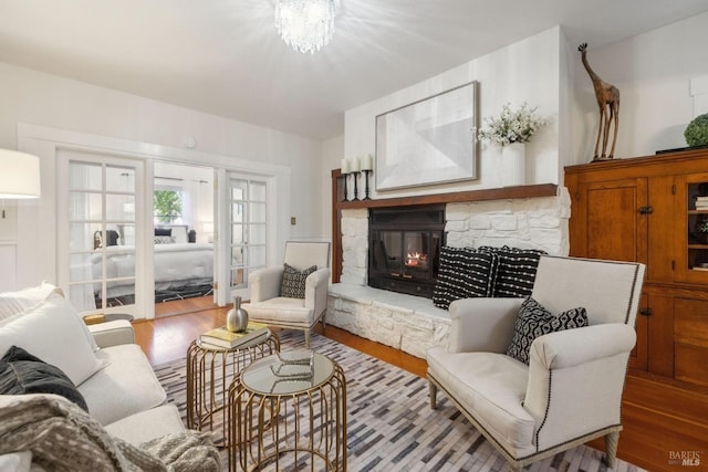 living room with wood finished floors and a stone fireplace