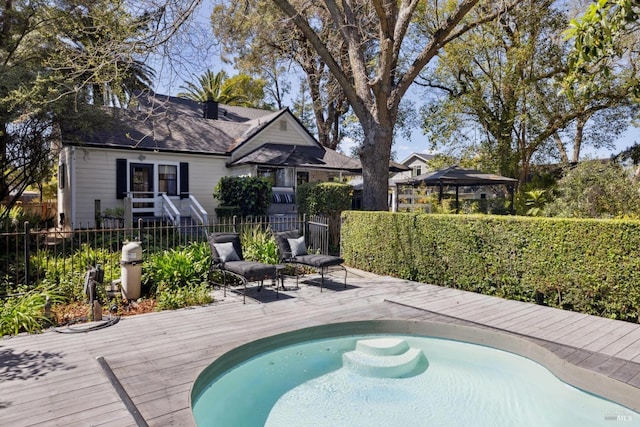 view of swimming pool featuring a wooden deck and fence private yard