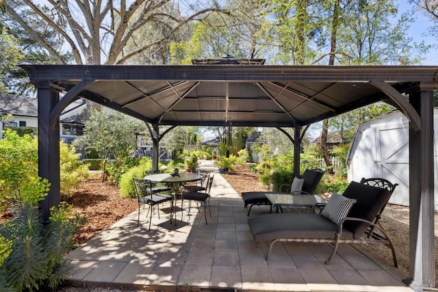 view of patio with a gazebo, outdoor dining space, an outbuilding, and a shed